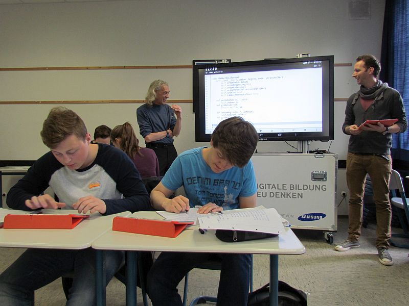 Programmieren mit Tablet-PCs im Informatik-Kurs - im Hintergrund Ludger Humbert (l.) und David Beisel. 